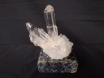 Druzia de cristal branco, em formato de ponta, com base em granito azul. Peso 560 gramas.
