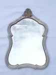 Antigo espelho  com moldura  moldada, encimado com florão patinado na cor beje .