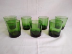 Sete copos em vidro na cor verde, sendo  2  em vidro fino e modelo diferente e 5 em vidro grosso todos na cor verde.