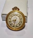 Relógio de bolso MONDAINE, ANCRE 17 RUBIS, à corda, caixa de metal dourado lavrado com folhas, mostrador branco com algarismos romanos em negrito.