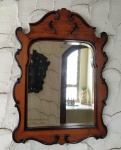 Espelho em madeira de lei ricamente torneado com vidro bisotado . Mede: 61x85 cm.