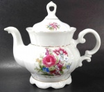 PORCELANA REAL - Bule para chá em porcelana branca decorada por rosas em policromia. Mede 19 cm de altura por 22 cm de comprimento.