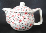 Bule em para chá em porcelana decorado por rosas em sutil policromia - possui difusor em aço - mede 11 cm de altura por 16 cm da alça ao bico.