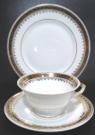 PORCELANA MAUÁ - Trio para chá e bolo manufaturado em porcelana branca com pintura em ouro e faixas de arabescos. Mede 5,5 x 10,5 cm a xícara, 15 cm de diâmetro o pires e 17 cm de diâmetro o prato de bolo.