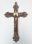 Crucifixo em bronze fundido, ricamente cinzelado com elementos fitomórficos, apoiando a imagem de Cristo Crucificado. Medindo 29 x 18 cm