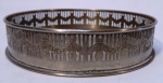 salva circular de metal prateado nacional, manufatura "Wolff", ornada com varanda em fenestras e desenhos de guirlandas. DESGASTES. Medindo 15 cm de diâmetro