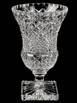 Belíssima Floreira com Pé Alto, executada em grosso cristal, lavrada em bico de jaca e de diamante, base quadrada, com figura estelar, bordas serrilhadas. Dimensões: 23,5 cm X 14 cm (Alt./Diâm.).