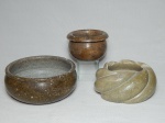 Três peças em pedra sabão: cinzeiro em caneluras, bowl em rajado e cachepot pequeno na cor bege. 6 x 11cm, 7 x 14cm e 6 x 10cm. - -