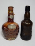 Duas garrafas de bebidas antigas: a) Em porcelana marrom do whisky escocês Chivas. Vazia. Alt. 23cm. b) Em vidro, da cervejaria alemã Altermünster. Alt. 23cm.