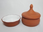 Duas peças confeccionadas em barro cozido: bowl revestido por porcelana branca na parte interna; e pote com tampa na forma de ponta-de-lança. 4 x 14cm e 17 x 15cm.