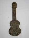 Placa de parede em bronze argentino moldado na forma de violão, decorado em alto relevo com cenas de violeiros típicos. 33 x 12cm.