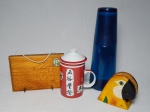 Quatro peças: a) Caneca com tampa em porcelana chinesa vermelha e branca, decorada com caracteres chineses. Alt. 15cm. b) Garrafa em plástico azul, copo formando tampa. Alt. 26cm. c) Porta-chaves, pirogravado com desenho de Santuário da Basílica de São Francesco di Paola. 13 x 17cm. d) Porta-guardanapos na forma de arara. 10 x 9 x 4cm.