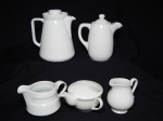 Cinco peças parte de serviço de porcelana branca: jarra, 2 bules e 2 leiteiras. Alt. jarra 17cm, bule menor 6cm.