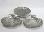JOHN SOMMERS - Três petisqueiras em estanho polido na forma de conchas. Uma delas com marca da refinaria Shell. Apresenta desgastes.  3 x 15 x 16cm