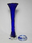 Duas peças em vidro ao gosto de Murano: a) Floreira alta moldada em formato retorcido, vidro translúcido e azul escuro. Alt. 39cm. b) Cinzeiro para 3 cigarros, aplicações azuis no interior. 3 x 10cm.