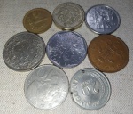 Oito moedas estrangeiras - origens diversas, bem como valores e datas de cunhagem. No estado mostrado nas fotos