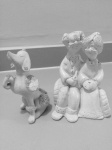 Lote com duas esculturas a maior com 17 cm: 1) grupo escultórico com casal de idosos 2) poodle 'cachorro de madame"