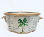 Cachepot em porcelana decorado com coqueiros, com duas pegas laterais. Med. 12x30 cm.