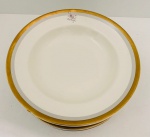 Porcelana Schmidt, Ivory China  Nove pratos fundos em porcelana na tonalidade marfim, borda com detalhes em ouro e decorada com flores. Med. Diâm. 23 cm.