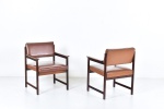 Sergio Rodrigues (Atribuído) - Par de cadeiras de braços executadas em jacarandá maciço com assentos e encostos revestidos em courvin marrom. Brasil, c. 1960. 78 x 58 x 60 cm.