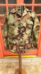 Gandola / Jaqueta Militar Americana Camuflada. Tamanho X-SMALL REGULAR - Fechada mede 48 cm na altura da cintura por 72 cm de comprimento medidos da costura da gola até a barra. Um botão está partido ao meio.