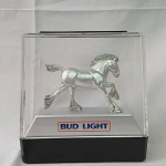 Budweiser - Linda Capsula em acrílico, com a figura de um cavalo  ` The Budweiser Light Clydesdale ` e tema da Bud Light. Diz que esse cavalo forte e livre de espírito simboliza a rica tradiçãoe comprometimento que são os lemas de se fabricar uma Bud Light. Mede 25x26x8,5cm. Lindo para coleção e decoração de bar e ambientes ligados a cerveja