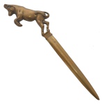 Espátula para abrir correspondência em metal amarelo. Ponteira com figura de animal. Ass. no verso. 26 cm.