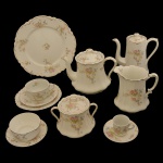Serviço para chá e café de porcelana inglesa. No fundo marca da manufatura: Johnson & Bros. England. Constando de: Bule para café (19 cm), bule para chá (18 cm), leiteira (15 cm); açucareiro (13 cm), manteigueira (6 x 14 cm), prato para bolo (25 cm), 12 xícaras para chá com pires (6 x 11 cm / 15 cm pires), 10 xicaras para café (5 x 6 cm / 11 cm o pires) e 12 pratinhos para pão (18 cm).