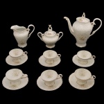 Serviço para chá em porcelana nacional. No fundo marcas da manufatura: Porcelana Schmit, Santa Catarina. Made in Brasil. Constando de: Bule (20 cm), Leiteira (12 cm), açucareiro (14 cm) e 5 xícaras com pires (5 x 9 cm / 11 cm pires).