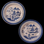 Par de pratos de porcelana chinesa apresentando decoração em tons de azul e branco. Centro com árvores, casas e montanhas. China. 22 cm.