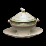 Molheira com presentoir de porcelana francesa. Superfície de fundo branco com friso verde. Pega da Tampa na forma de fruto. Sem marcas. 16 x 24 x 14 cm.