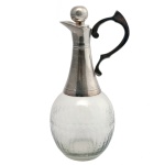 Decanter em cristal translucido, lapidado em losangos e pingos com pega e bocal em metal prateado. Séc. XX. 30 cm.