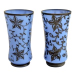 Par de vasos levemente abaulados em opalina de cor azul, ornamentados em overlay negro por galhos floridos. Bases circulares lisas. Séc. XX. 4 x 7,5 cm.