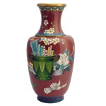 Vaso em metal esmaltado, em cloisonné, trazendo desenhos florais e outros motivos sobre fundo em tom acobreado. Bordas superior e inferior douradas. 30 x 15 cm. Bocal com 9 cm.