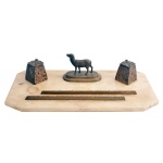 Conjunto para escritório montado sobre base em mármore rosa claro, decorado com figura de ovelha ao centro, ladeada por dois tinteiros, aparadores para canetas, sendo todas as peças em bronze. Base 45 x 23 cm. 10 cm (tinteiros).
