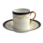 Xícara e pires para café em porcelana alemã Bavária, bordas em azul cobalto e decoração em dourado sobre fundo branco. Manufatura Rosenthal (Selb, 1917-1969). 5 x 6 cm / 10 cm pires.