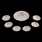 Conjunto para sobremesa de porcelana polonesa, constando de sete peças. Fundo de superfície branca com decoração floral. No fundo marca da manufatura: Tielsch Walbrzyon. Made in Poland. 6 x 22 cm (maior).  3 x 13 cm (menores).