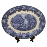 Travessa em porcelana inglesa. Superfície de fundo branco e decoração em tom de azul cobalto. Centro com paisagem e borda com flores. No verso marcas da manufatura e as inscrições: "Enoch Woods English Scenery" e "Wood & Sons England". Inglaterra. Séc. XIX. 36 x 28 cm.