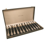 Conjunto com doze colheres para café de metal prateado. Cabo decorado com folhagens e texturizados.  Acondicionados em estojo original. 12 cm.