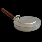 ST JAMES  Pegador de migalhas em metal liso, espessurado a prata. Cabo de madeira. Apresenta marcas do design brasileiro. Brasil. Séc. XX. 26 cm com cabo de madeira.