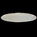Travessa de formato oval em porcelana nacional. Fundo de superfície branca com frisos dourado nas bordas. Marca da manufatura: Real, São Paulo. Made in Brazil.  63 x 22 cm.