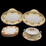 Conjunto em porcelana inglesa, formado por dois covilhetes, um consomé e seis pratos, em tons de creme e branco, decorado com arranjos florais e outros elementos figurativos.  Manufatura Alfred Meakin (Tunstall) Ltd. (1875-1976); estampa empregada a partir de 1930.  26 x 19 cm. Um com bicado.