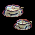 Conjunto em porcelana japonesa formado por duas xícaras com pires sendo uma para chá (5 x 12 cm / 14 cm) e outra para café (4 x 10 cm / 12 cm) em tonalidades cereja, azul cobalto e branco com arranjos florais e aplicações em dourado. Manufatura Shofu China, Nagoya, Japão.