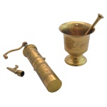 Conjunto em metal dourado formado por pilão (10 x 9 cm), socador (13 cm) e moedor de grãos (22 cm), cinzelado em desenhos de folhas e flores.