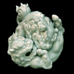 Escultura em porcelana chinesa representando casal de Cães de Fó em postura de luta. Séc. XX. 19 x 23 cm.