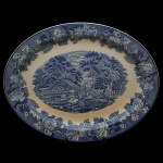 Travessa em porcelana inglesa, Superfície de fundo branco e decoração em tom de azul cobalto, Centro com paisagem e borda com flores. No verso marcas da manufatura e as inscrições: "Enoch Woods English Scenery" e "Wood & Sons England". 36 x 28 cm.