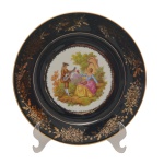 Prato em porcelana francesa em azul cobalto, circundado com flores e frutos em ouro 22k e decoração de cena galante em tema de Fragonard. No fundo as inscrições: Castel, Limoges  France. 26,5 cm.