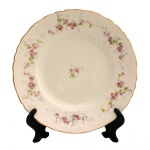 Prato em porcelana inglesa, borda recortada e em alto relevo. Delicados ramos de flores na borda e ao centro sobre fundo branco. Manufatura: John Maddock & Sons LTD. (1855-meados anos 1960). 20,5 cm.