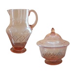 Conjunto formado por jarra e compoteira em vidro cor salmão translúcido com desenhos de losango em relevo em suas superfícies. 23 x 11 cm (jarra); 20 x 15 cm. (compoteira).