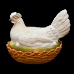 Manteigueira na forma de galinha em porcelana policromada. 20 x 24 x 16 cm. Apresenta alguns bicados.